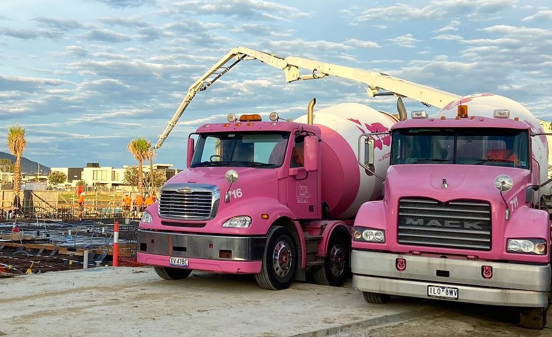 Two Vicmix pink concrete trucks at a construction site.